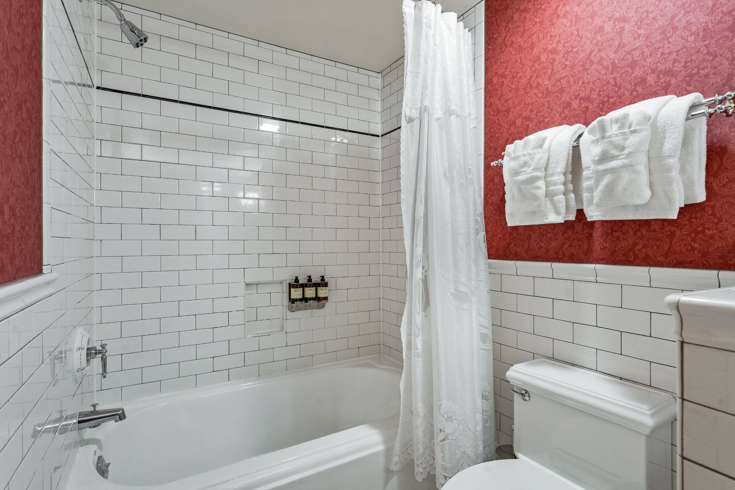 Un baño con una bañera blanca, un inodoro y una cortina de ducha.