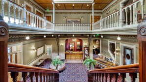 A grand lobby with a central staircase, ornate railings, and a checkered floor. - Beaumont Hotel & Spa - Adults Only (Ouray)