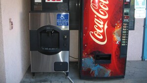 Two vending machines, one labeled ICE and the other Coca-Cola, with a wheelchair accessibility sign. - Royal Inn Motel Long Beach (Long Beach)