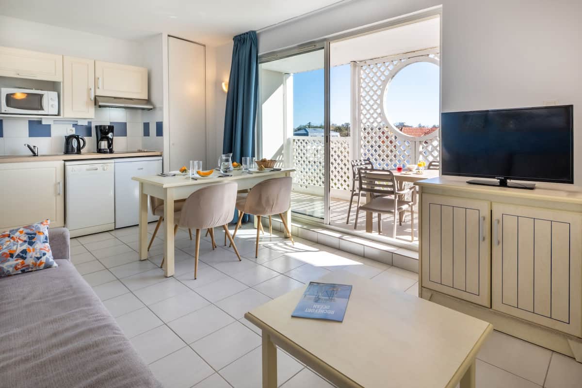 Une cuisine moderne avec un coin repas, un téléviseur à écran plat et un balcon avec vue.