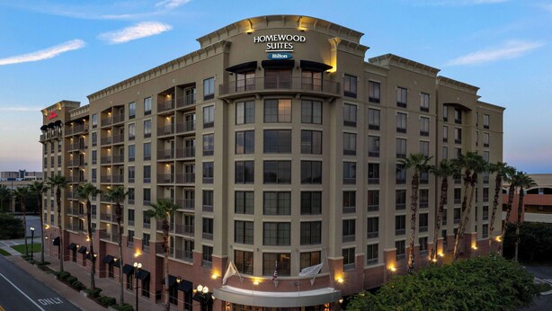 A multi-story hotel with a curved facade, multiple balconies, and a well-lit entrance. - Homewood Suites by Hilton Jacksonville Downtown-Southbank (Jacksonville)