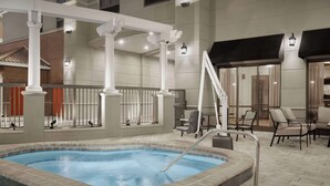 An indoor swimming pool with a hot tub, surrounded by lounge chairs and a staircase. - Homewood Suites by Hilton Jacksonville Downtown-Southbank (Jacksonville)