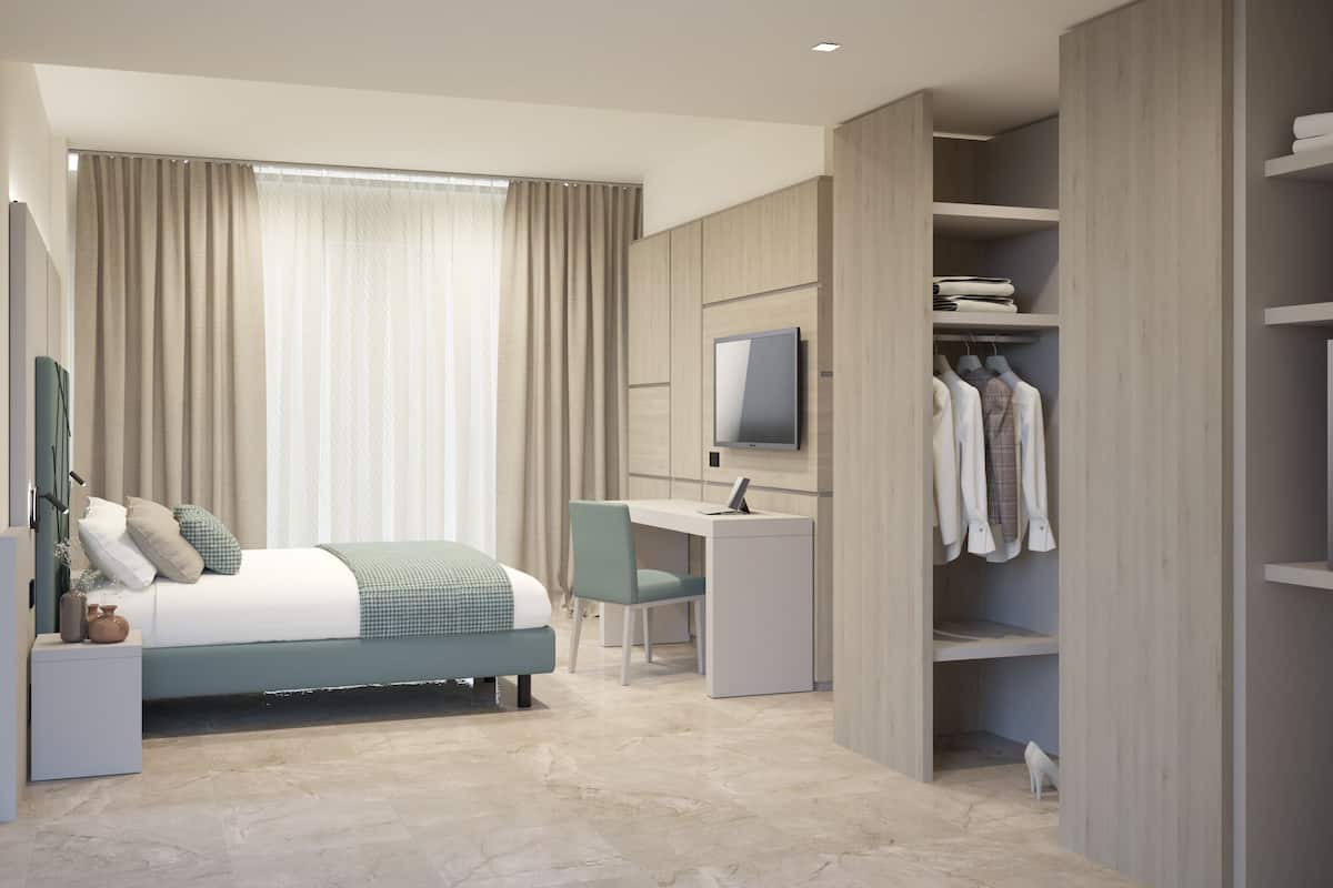 A modern bedroom with a bed, a desk, a TV, and a walk-in closet.