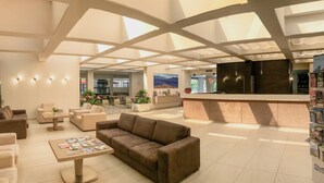 A spacious lobby with a high ceiling, a reception desk, and seating areas. - Hotel Residence Holiday (Sirmione)