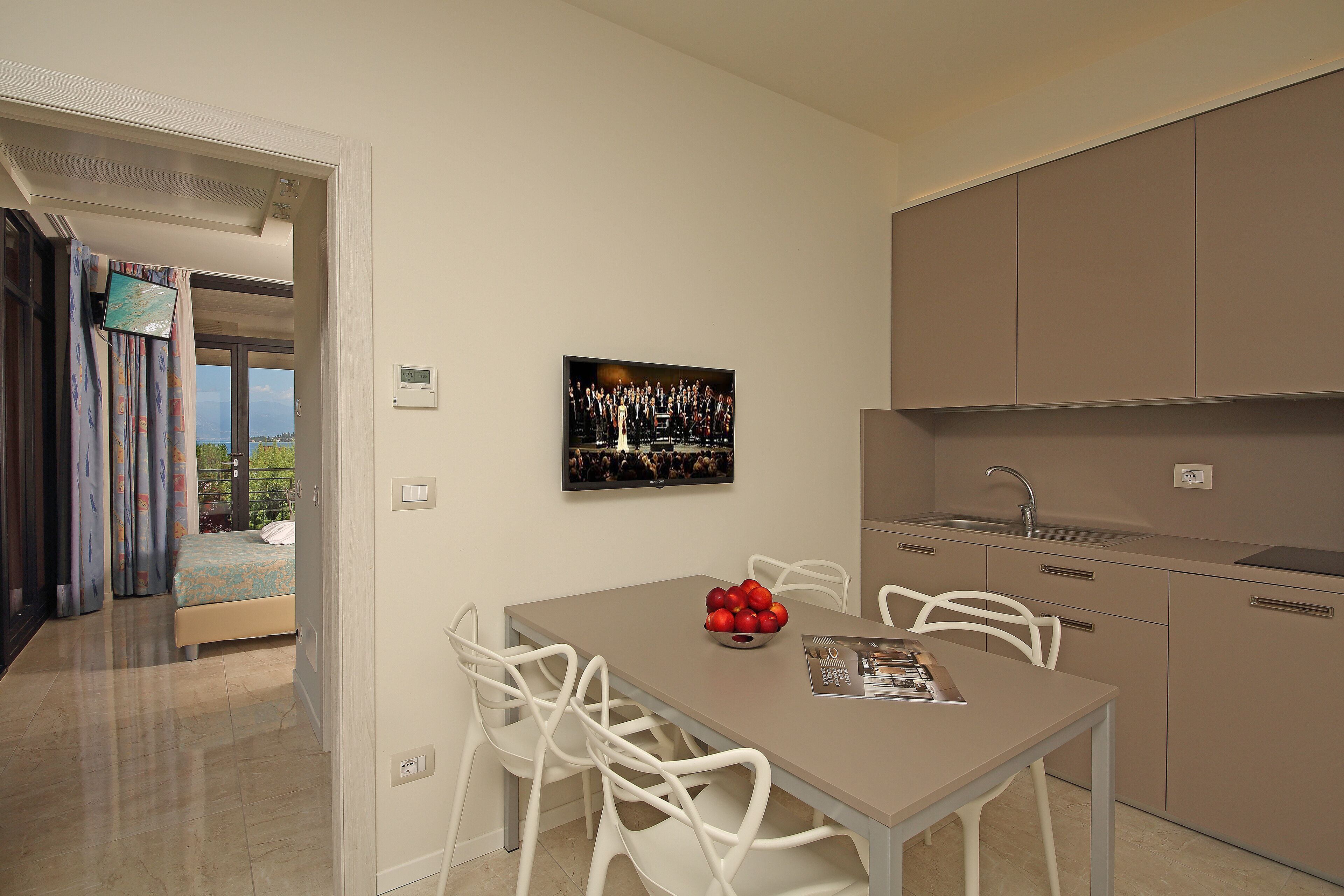 Una cocina moderna con comedor, cama y un amplio ventanal.