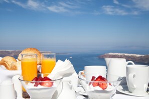Un desayuno con una vista panorámica del mar y las montañas al fondo.