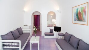 A modern living room with a sofa, a small table, a TV, and a painting on the wall.