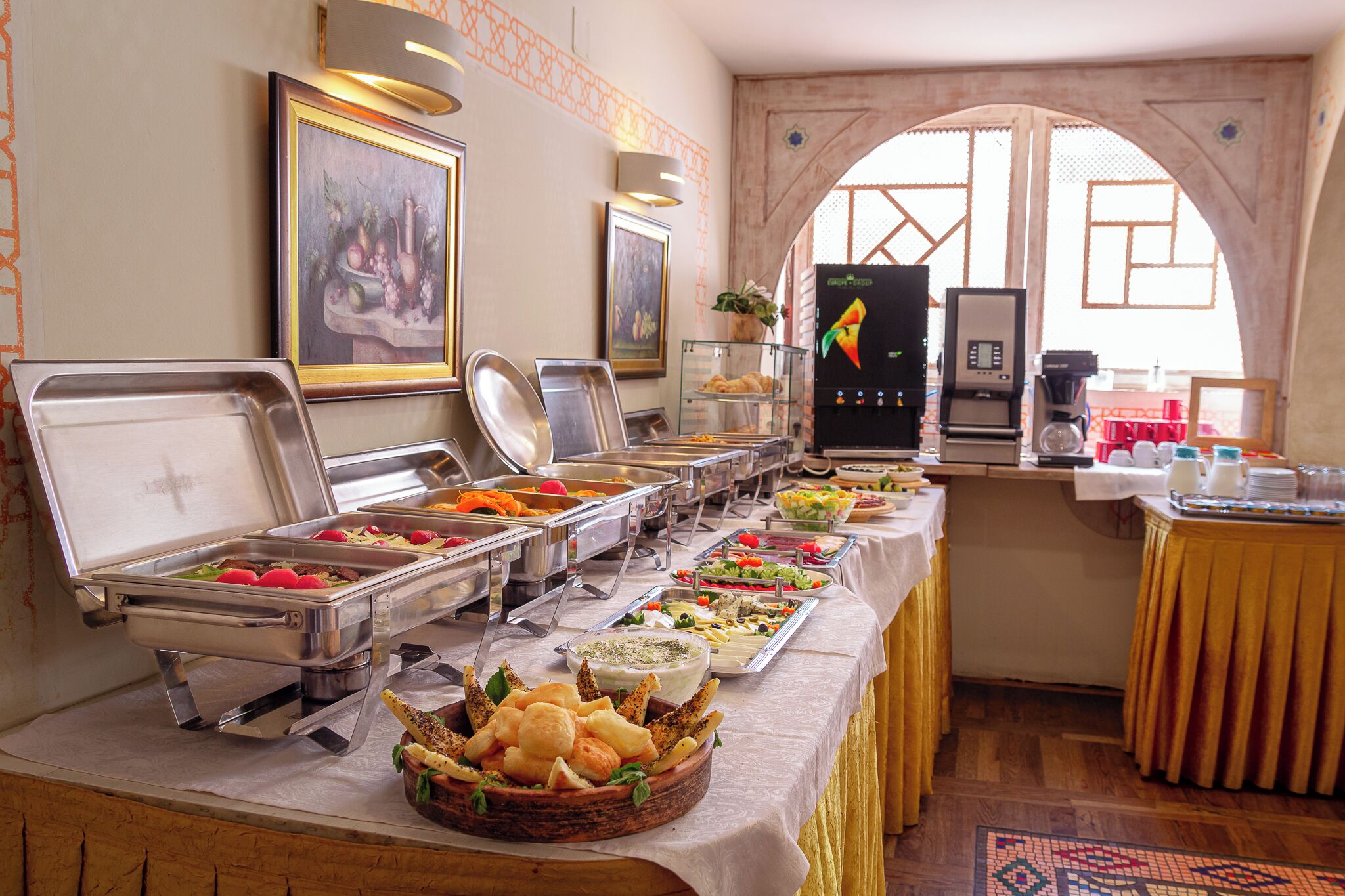 A buffet with various food items and a coffee machine.