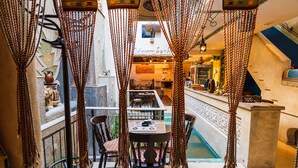 Un restaurant chaleureux avec un plafond haut, des murs en briques apparentes et un long comptoir.