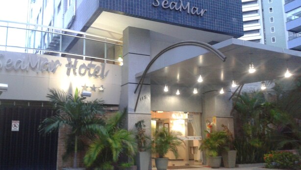 The SeaMar Hotel entrance with a modern design, including a curved overhang and potted plants. - Seamar Hotel (Fortaleza)