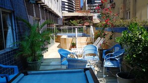 A narrow outdoor patio with blue chairs, a small pool, and potted plants. - Seamar Hotel (Fortaleza)
