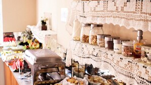 A buffet with various food items, including bread, pastries, and condiments. - Seamar Hotel (Fortaleza)