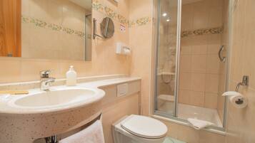 Un baño con lavamanos, inodoro y ducha.