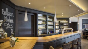 Eine moderne Bar mit einer Holztresen, Barhocker und Regalen voller Gläser.