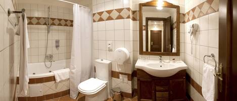 A bathroom with a shower, toilet, sink, and mirror.