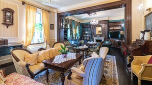 A traditional room with a fireplace, a large bookshelf, and a dining area with a table and chairs. - Boutique hotel Casa del Sole (Timisoara)