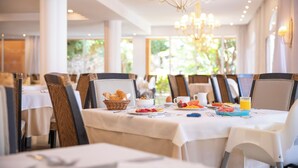 A dining area with tables set for breakfast, including fruits, pastries, and beverages. - Grupotel Club Turquesa Mar (Ciutadella de Menorca)