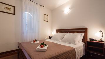 Una habitación de hotel con una cama, una mesita de noche, una lámpara y un cuadro en la pared.