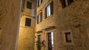 A narrow alleyway with stone buildings, a potted plant, and a sign. - Villa Sv. Petar (Trogir)
