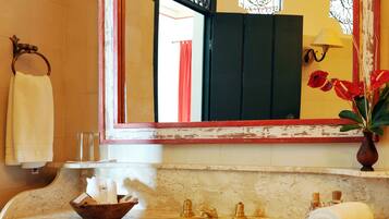 A bathroom with a sink, mirror, and red cabinet.
