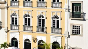 Un immeuble à la façade jaune, doté de nombreux balcons et surmonté d’un toit en tuiles.