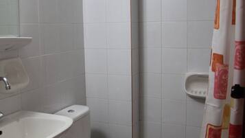 Un baño con lavamanos, inodoro y cortina de ducha.