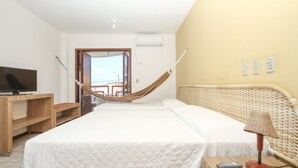 A hotel room with a bed, a desk, a chair, a lamp, and a television. - Marambaia Apart Hotel (Natal)