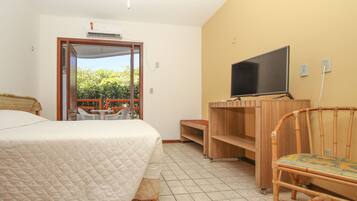 A bedroom with a bed, a TV, a chair, and a desk.