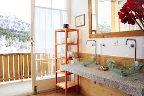 Een bad/douchecombinatie, een diep bad, een haardroger, pantoffels