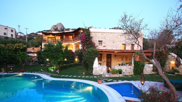 A pool area with a stone building in the background. - Sandima 37 Suites Hotel (Bodrum)