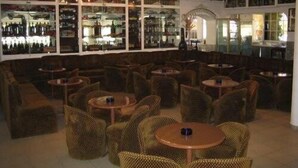 A bar area with wicker furniture and a wine display. - Torre Velha (Albufeira)