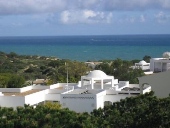 A coastal resort with white buildings, a clear view of the sea, and lush greenery. - Torre Velha (Albufeira)