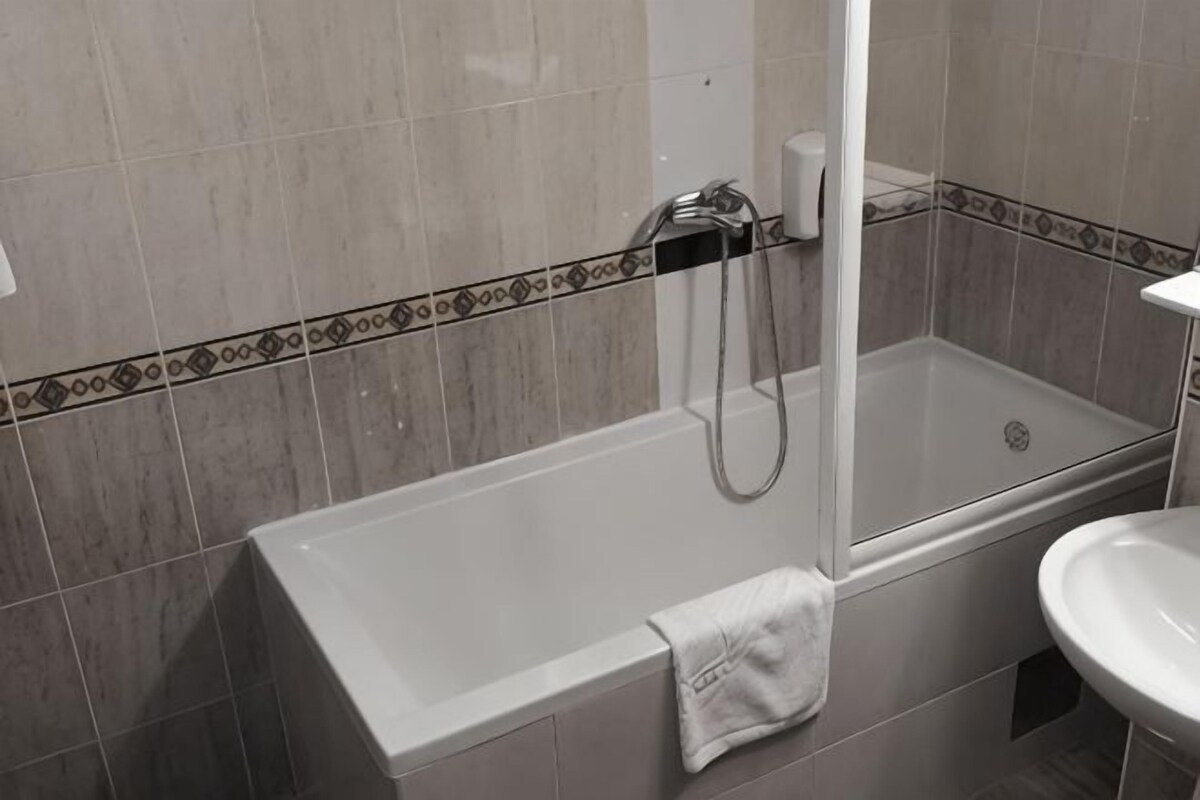 A bathroom with a bathtub, a shower, and a sink.