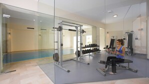 A modern gym with glass walls, weightlifting equipment, and a bench. - St Nicolas Elegant Residence (Paphos)