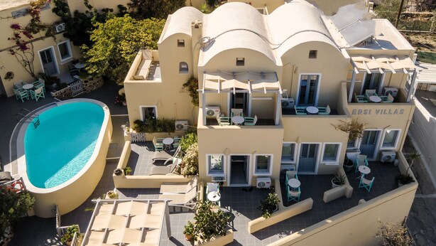 Un hotel de varios pisos con piscina, mobiliario exterior y estilo arquitectónico mediterráneo.