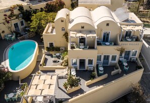 Een meerlaags hotel met een zwembad, terras en een mediterrane bouwstijl.
