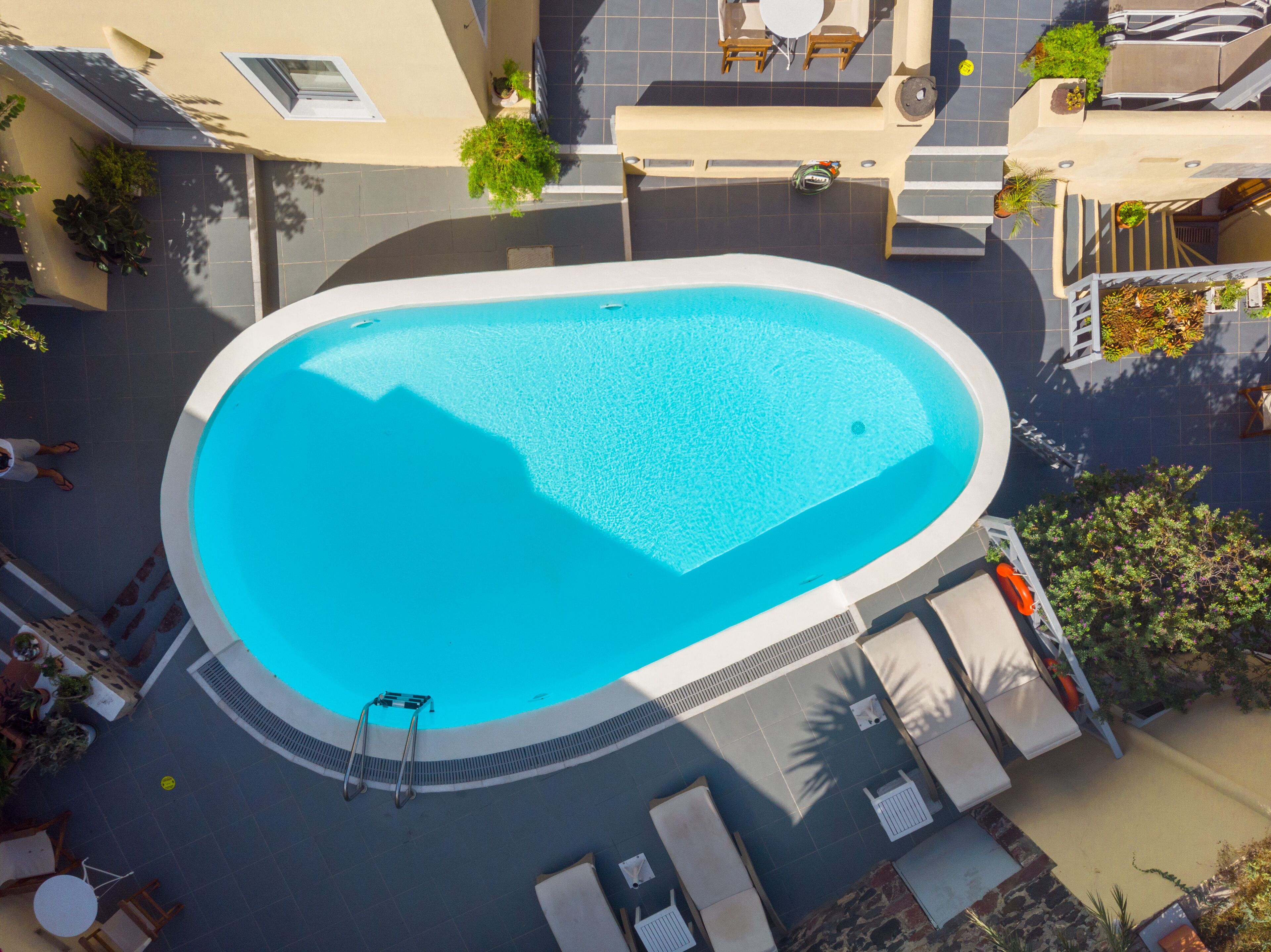 An aerial view of a swimming pool with lounge chairs and a lifeguard stand.