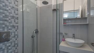 Ducha, cabezal de ducha tipo lluvia, secador de pelo y toallas