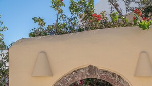 Entrada de un edificio con un letrero que dice 'ERSI VILLAS', un arco y una vista al interior.