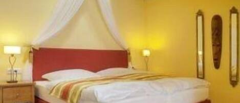 A bed with a canopy, a nightstand, and two wall mirrors.