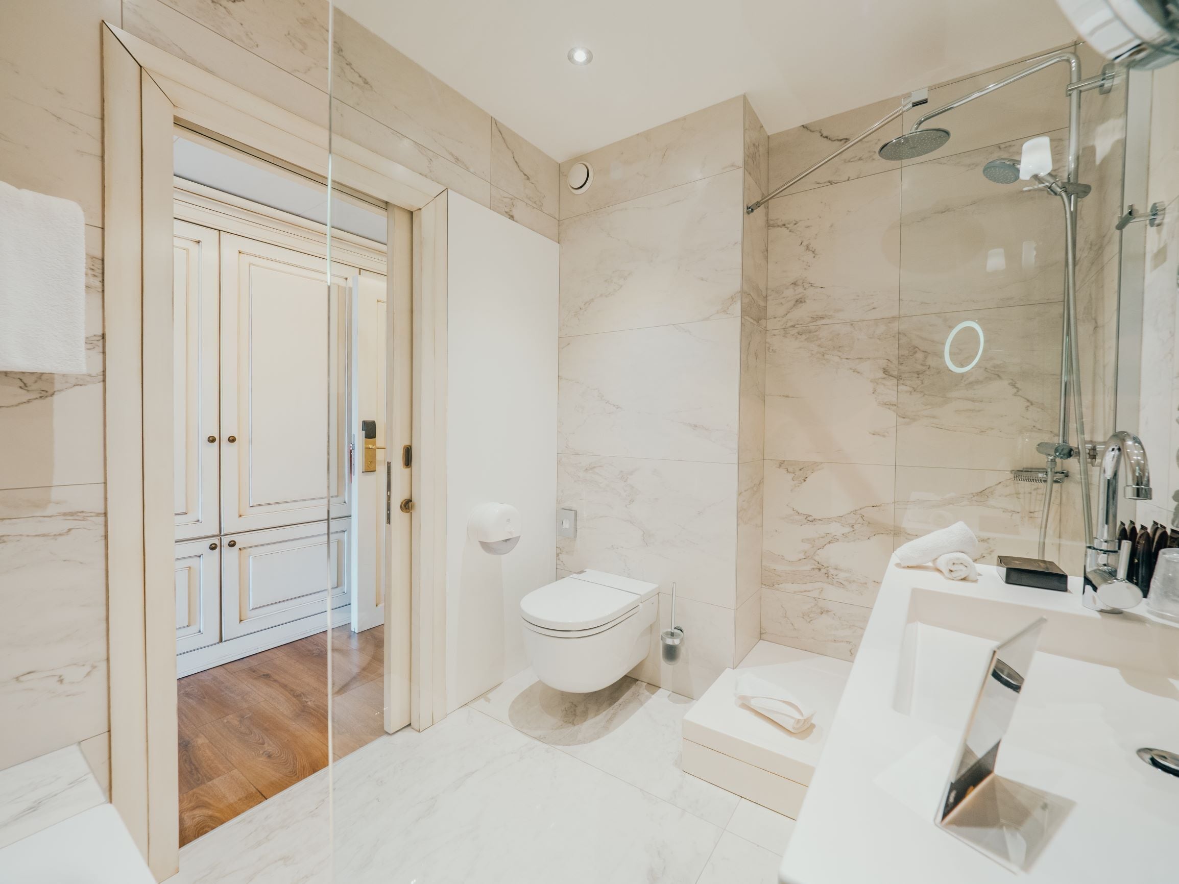 A modern bathroom with a toilet, shower, and sink.