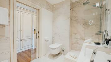 A modern bathroom with a toilet, shower, and sink.