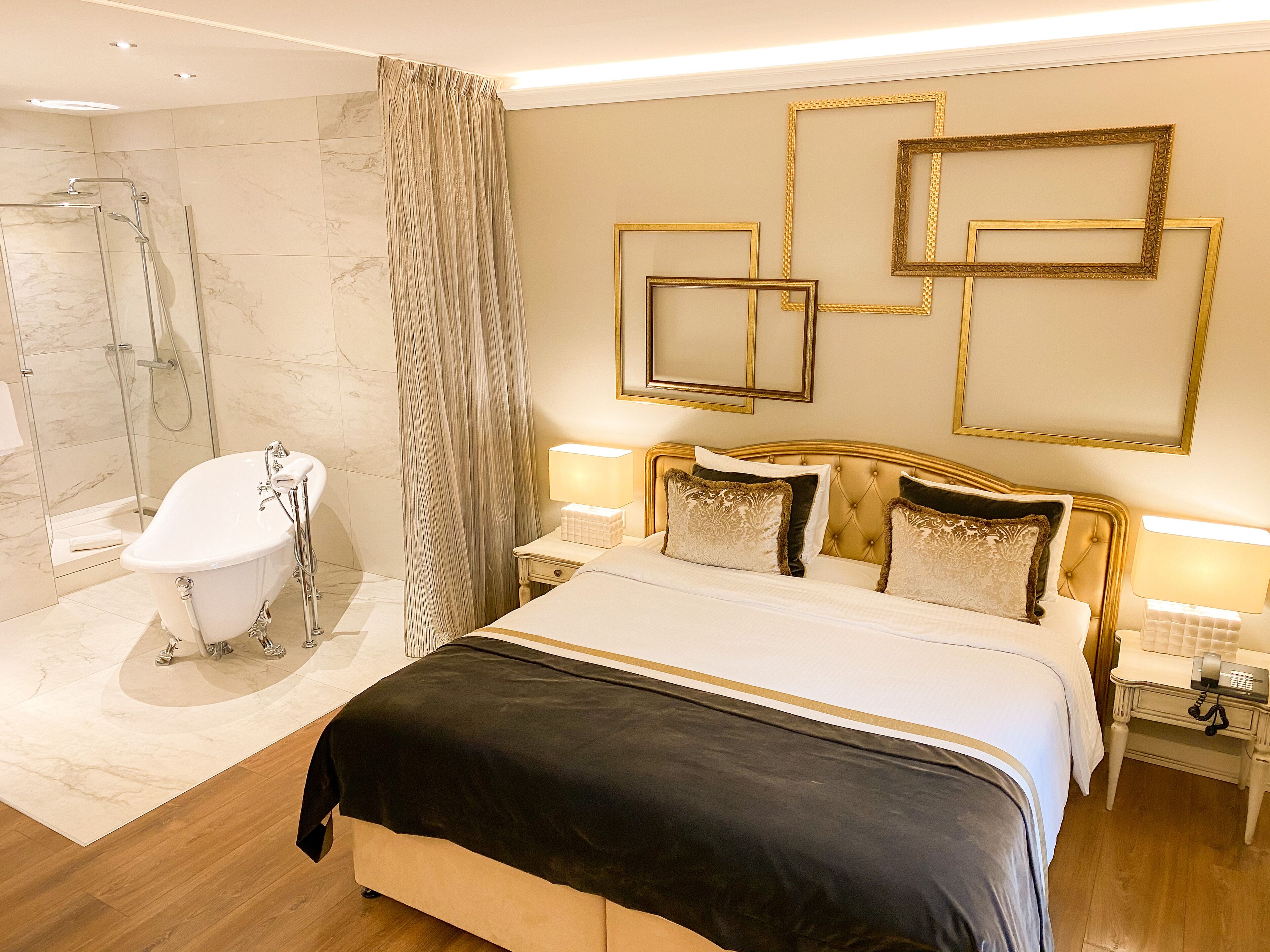 A hotel room with a large bed, a bathroom with a bathtub, and a shower.