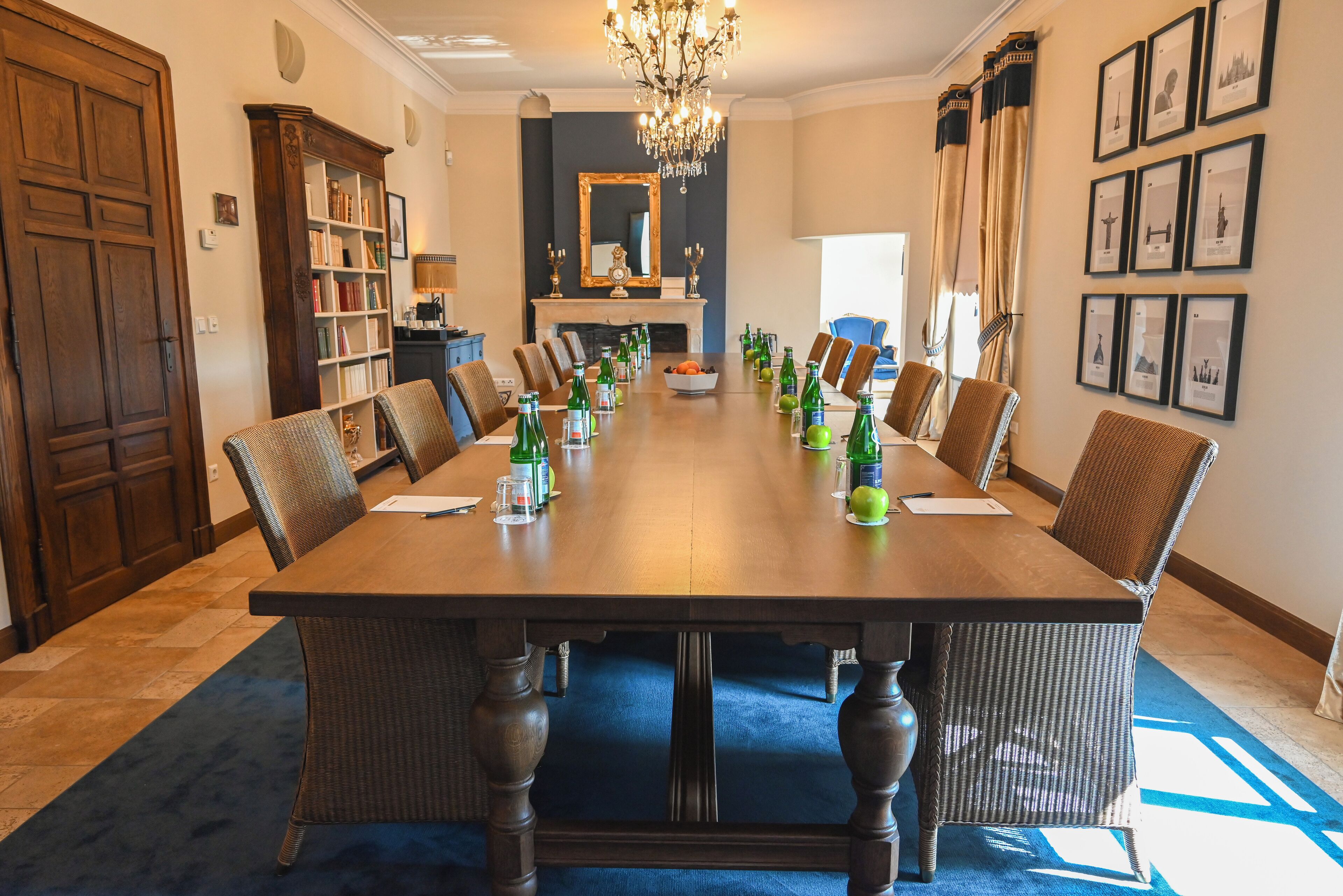Een formele eetzaal met een lange tafel, stoelen en een kroonluchter.