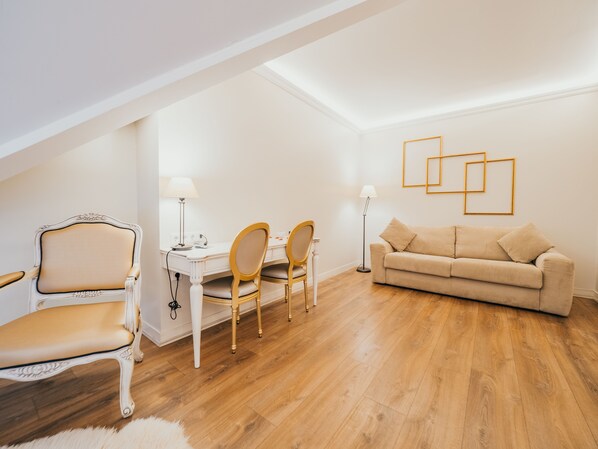Una habitación con una mesa de comedor, dos sillas, un sofá y una lámpara de pie.