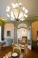 Un comedor con candelabro, mesas y sillas de madera.