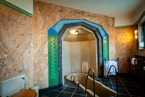 Une salle de bain avec une baignoire sur pieds, des toilettes et un lavabo.