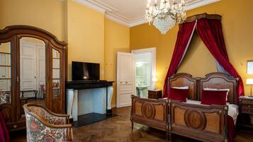 Un dormitorio con una cama de madera, televisor, candelabro y espejo.
