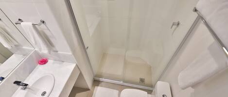 A modern bathroom with a glass shower enclosure, a white sink, and a toilet.