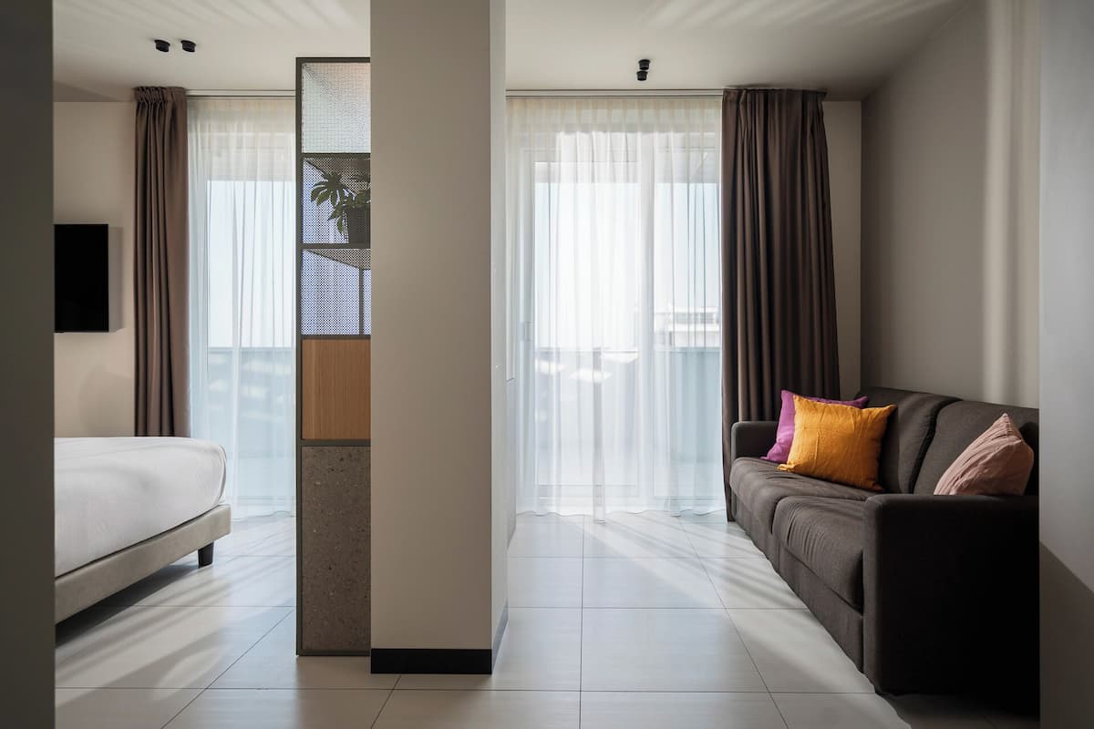 Junior Suite | Peralatan tempat tidur premium, bar mini, peti besi dalam bilik, meja